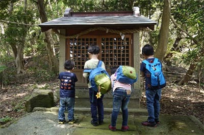 祠の前で立ち止まる子供たち