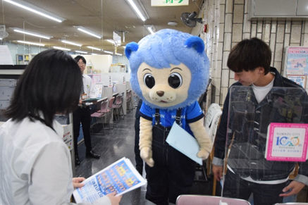沼田選手とアスルくんがホームゲームのチラシを配布している様子
