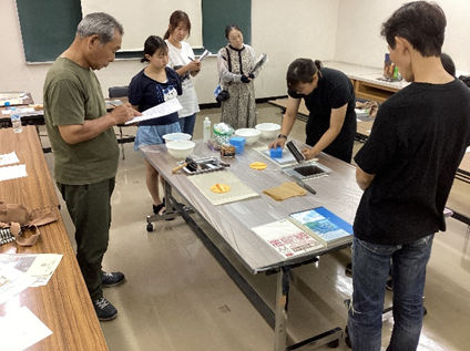 リトグラフの説明を聞く参加者の様子