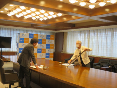 上村幸夫さんが市長にホッケーの説明をしている様子