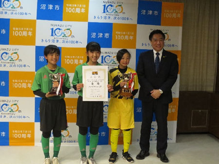 サッカークラブ「クワトロガールズFC」の皆さんと市長の記念撮影の様子