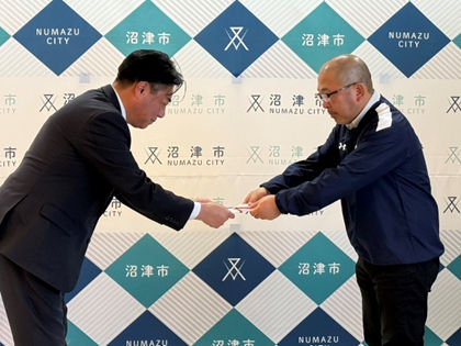 バスケットボールチーム「IZURASHI」の監督から寄附金を受け取る市長の様子