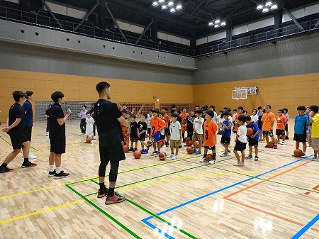 バスケットボール教室でプロの説明を聞く子どもたちの様子