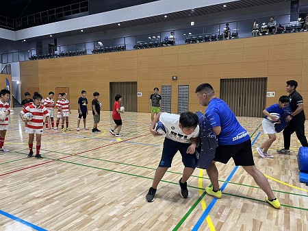 ラグビー教室でタックルの練習をする子どもたちの様子