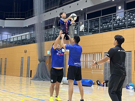 ラグビー教室のプロ選手に持ち上げられる子供の様子