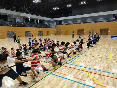ラグビー教室に参加した子供たちとプロ選手の綱引きの様子