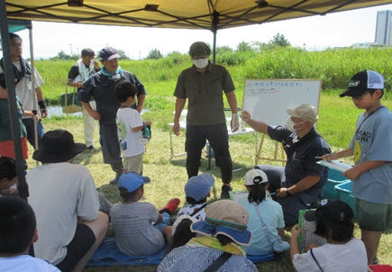 捕まえた水生生物を確認している子供の様子