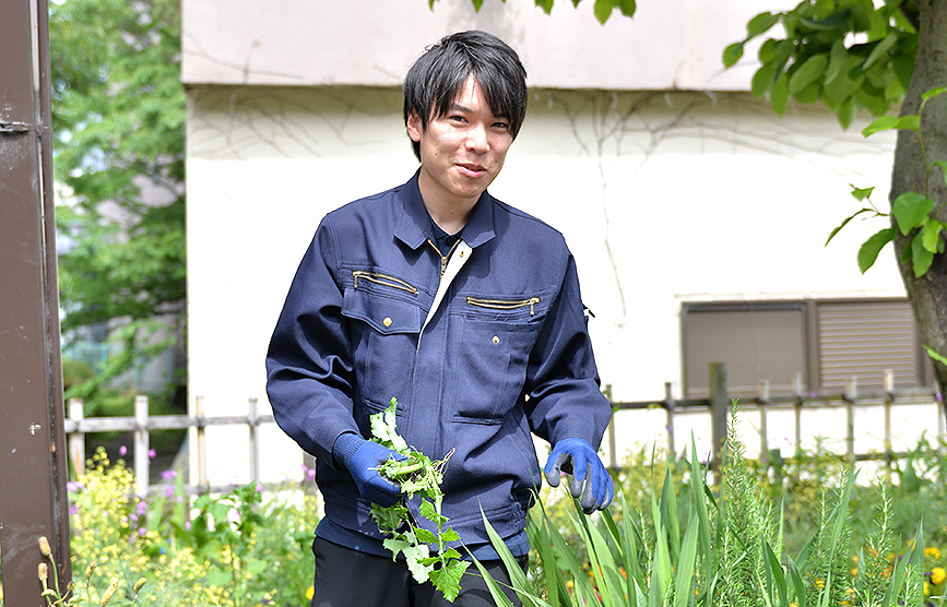 花壇で花の世話をする小池ひろきの写真